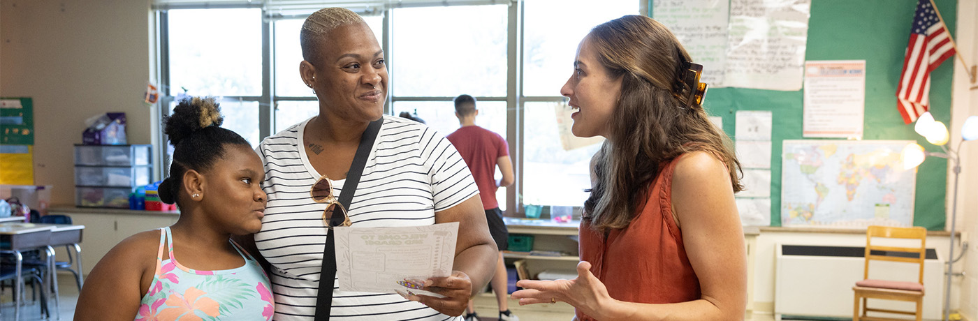 teacher speaking to student and parent